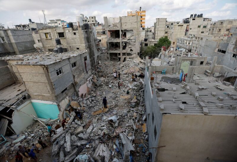 Palestinians gather on the rubble of houses at the scene where senior commander of Islamic Jihad militant group Khaled Mansour was killed in Israeli strikes, in Rafah in the southern Gaza Strip, August 7, 2022