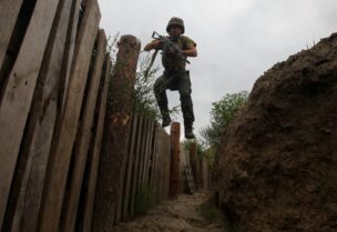 A member of the Ukrainian National Guard jumps into a trench at a position near a front line, as Russia's attack on Ukraine continues, in Kharkiv region, Ukraine August 3, 2022. REUTERS/Vyacheslav Madiyevskyy/File Photo