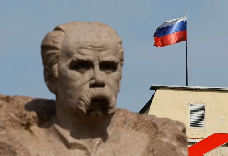 The Russian flag flies on the top of a building, as a monument to Ukrainian poet Taras Shevchenko is seen in the foreground, in the course of Ukraine-Russia conflict