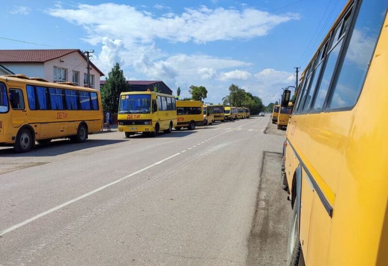 Buses for emergency evacuation are parked on the roadside in Azovskoye settlement following an explosion at a Russian military warehouse in the Dzhankoi district, Crimea