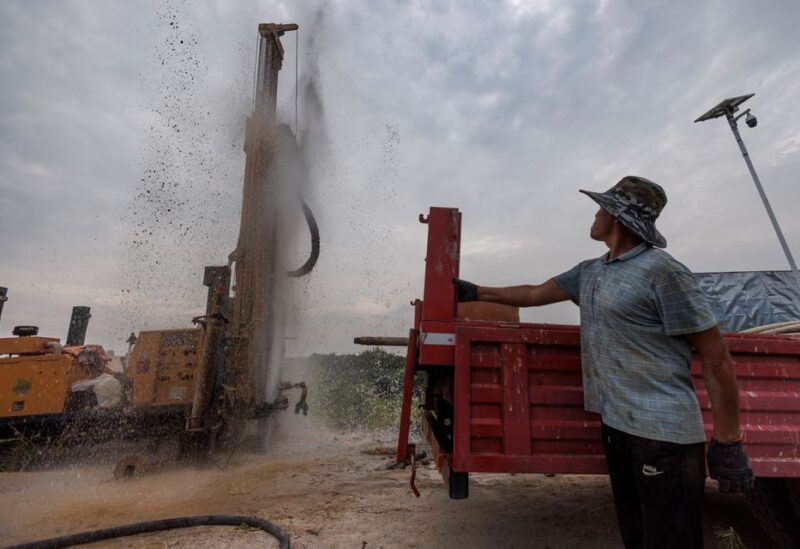 Head of a drilling crew Gao Pucha watches as his drill hits water as the region experiences a drought outside Jiujiang city, Jiangxi province, China, August 27, 2022. REUTERS/Thomas Peter