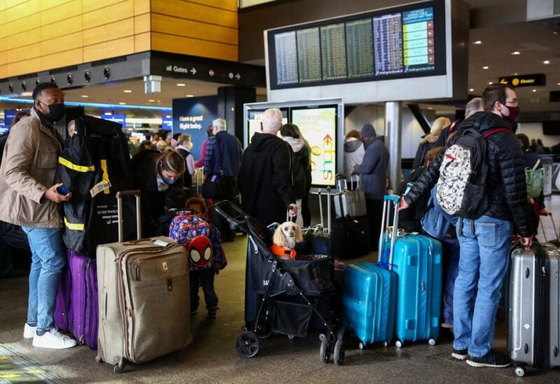 People wait in long check-in lines after dozens of flights were listed as cancelled or delayed at Seattle-Tacoma International Airport (Sea-Tac) in Seattle, Washington, U.S. December 27, 2021. REUTERS/Lindsey Wasson