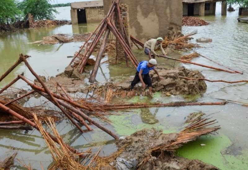 People retrieve bamboos from a damaged house following rains and floods during the monsoon season in Dera Allah Yar, district Jafferabad, Balochistan, Pakistan August 25, 2022. REUTERS/Amer Hussain