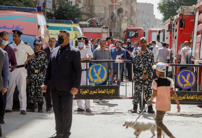 People and police gather near the scene where a deadly fire broke out at the Abu Sifin church in Giza, Egypt, August 14, 2022