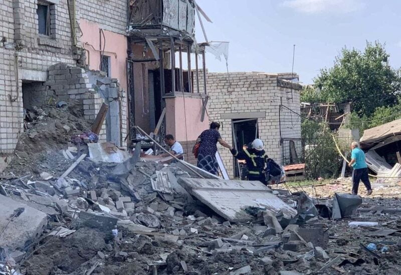A rescuer helps a woman to be evacuated from a residential building damaged by a Russian missile strike, amid Russia’s attack on Ukraine, in Voznesensk, Mykolaiv region, Ukraine August 20, 2022