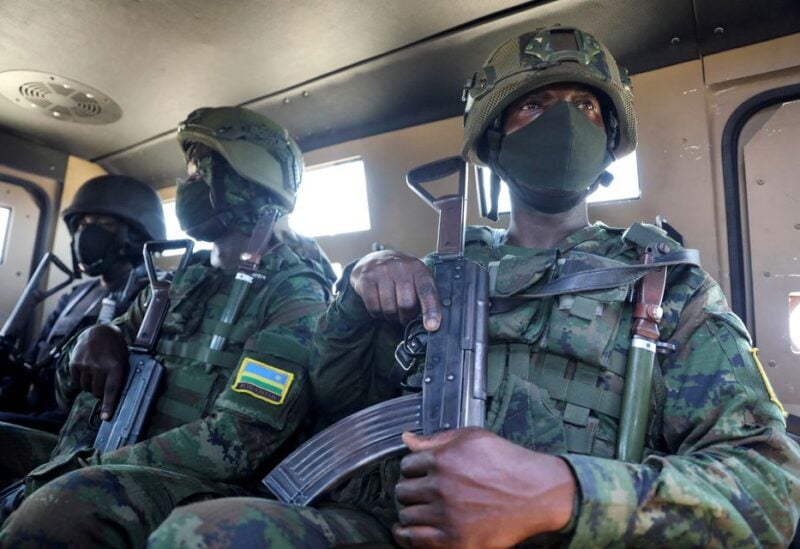 Soldiers from the Rwandan security forces sit inside an Armoured Personal Carrier