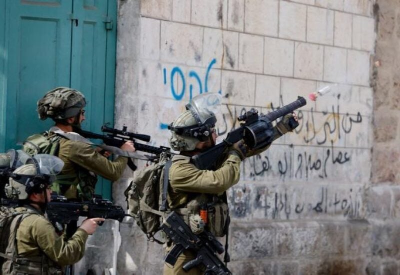 An Israeli soldier uses a weapon amid clashes with Palestinians in the West Bank.