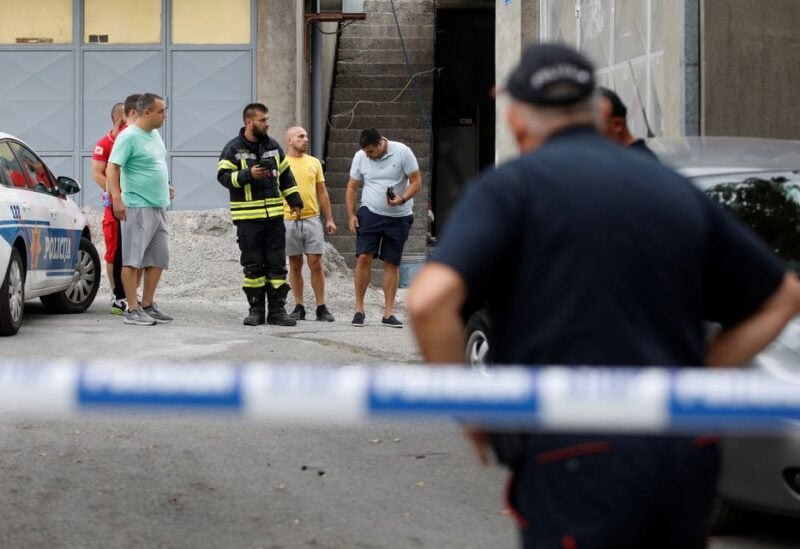 Rescue personnel talks to citizens at the crime scene of a mass shooting in Montenegro