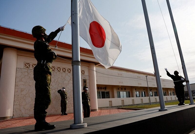 FILE PHOTO: Members of the Japan Ground Self-Defense Force (JGSDF) bring down the Japanese national flag in the early evening, at JGSDF Miyako camp on Miyako Island, Okinawa prefecture, Japan April 20, 2022. Picture taken April 20, 2022. REUTERS/Issei Kato//File Photo