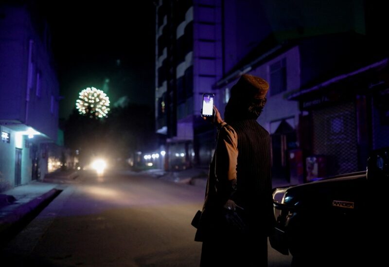 A Taliban fighter takes pictures on his mobile phone on the first anniversary of the departure of U.S. forces from Afghanistan, on a street in Kabul, Afghanistan, August 30, 2022. REUTERS/Ali Khara