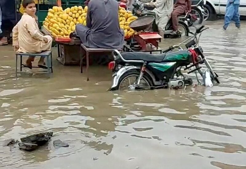 People and vehicles move around a flooded market in Charsadda, Pakistan July 30, 2022 in this screengrab obtained from social media video. Mudasir Khan/via REUTERS THIS IMAGE HAS BEEN SUPPLIED BY A THIRD PARTY. MANDATORY CREDIT. NO RESALES. NO ARCHIVES.