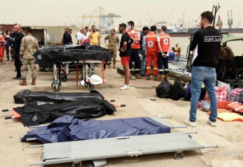 People stand near stretchers that are prepared for dead bodies after a boat capsized off the Lebanese coast of Tripoli overnight, at port of Tripoli, northern Lebanon April 24, 2022. (Reuters)
