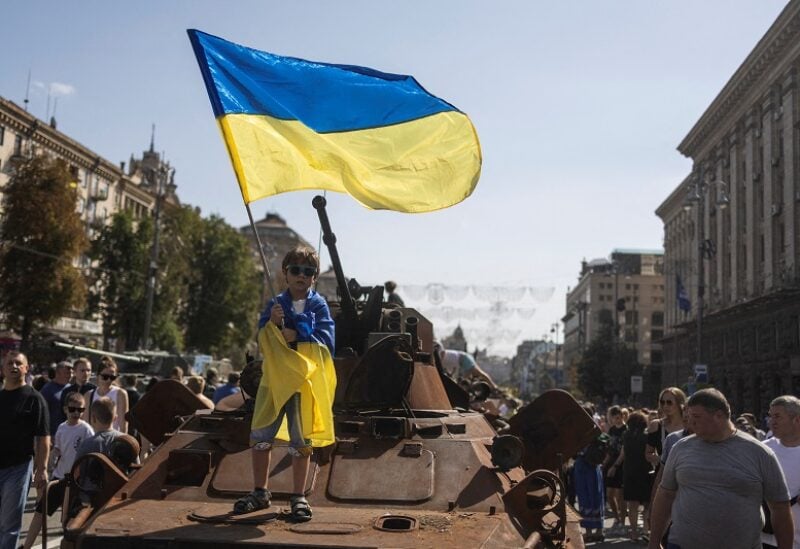 FILE PHOTO: A boy waves a national flag atop of armoured personal carrier at an exhibition of destroyed Russian military vehicles and weapons, dedicated to the upcoming country's Independence Day, amid Russia's attack on Ukraine, in the centre of Kyiv, Ukraine August 21, 2022. REUTERS / Valentyn Ogirenko/File Photo