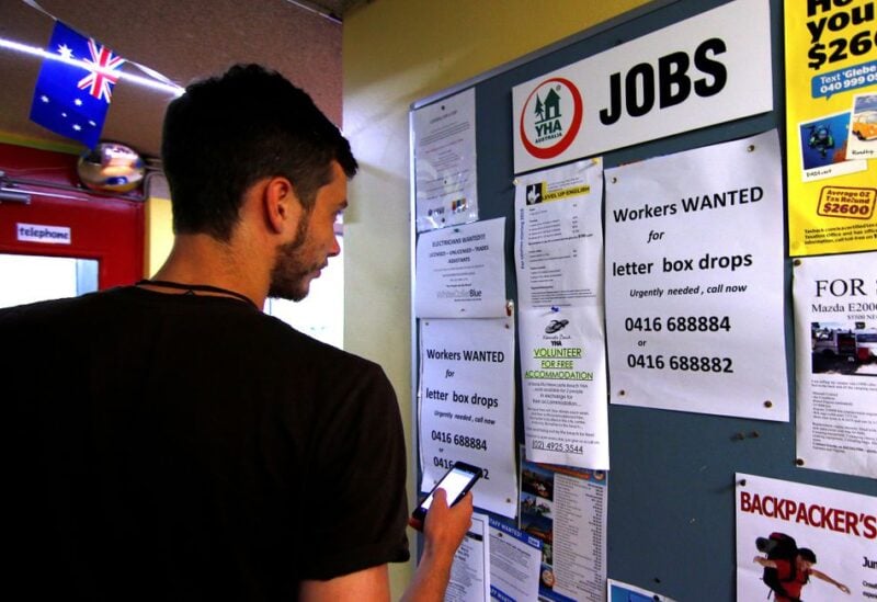 A man uses his phone to record a job add posted on a notice board at a backpacker hostel in Sydney, Australia, May 9, 2016. Picture taken May 9, 2016. REUTERS/Steven Saphore