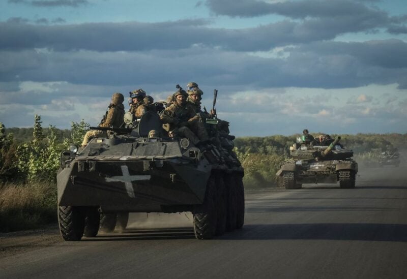 Ukrainian servicemen ride on Armoured Personnel Carrier (APC) and a tank, as Russia's attack on Ukraine continues, near the town of Izium, recently liberated by Ukrainian Armed Forces, in Kharkiv region, Ukraine September 19, 2022. REUTERS/Gleb Garanich