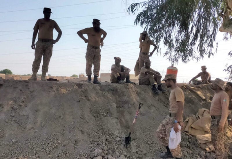 Members of Pakistan's Army guard and look after a dike to protect a power station, following rains and floods during the monsoon season, in Dadu, Pakistan on September 11, 2022. (ISPR)