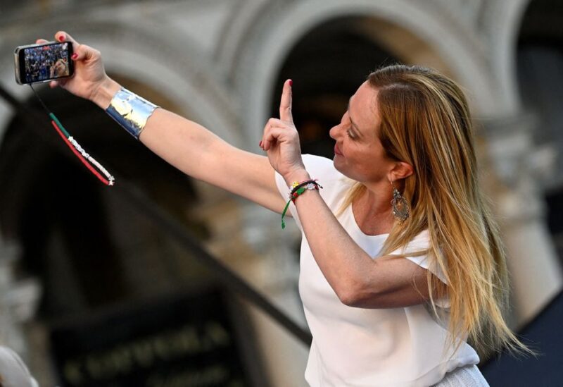 Giorgia Meloni, leader of the far-right Brothers of Italy party, takes a selfie during a rally in Duomo square ahead of the Sept. 25 snap election, in Milan, Italy, September 11, 2022. REUTERS/Flavio Lo Scalzo/File Photo