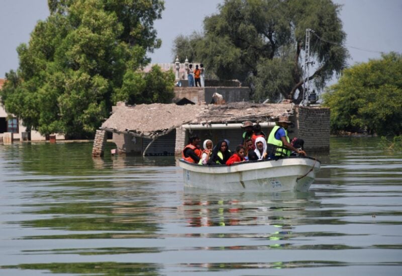 Rescued flood victims sit in a boat, following rains and floods during the monsoon season in village Arazi, in Sehwan, Pakistan, September 11, 2022. REUTERS/Yasir Rajput/File Photo