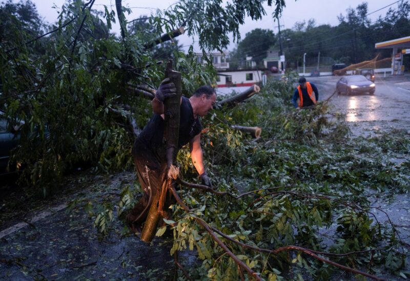 People clear a road from a fallen tree after Hurricane Fiona affected the area in Yauco, Puerto Rico September 18, 2022. REUTERS/Ricardo Arduengo