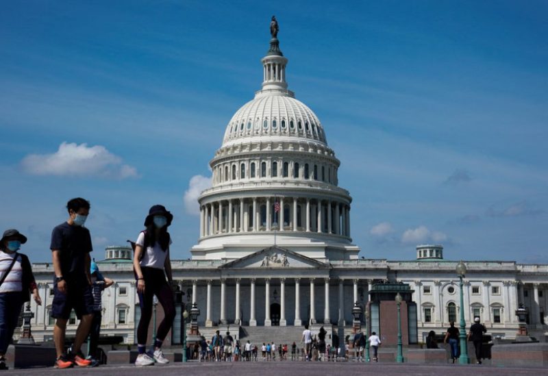 People wearing masks for protection against the coronavirus disease (COVID-19) walk past the U.S. Capitol in Washington, U.S., September 4, 2022. REUTERS/Elizabeth Frantz/File Photo