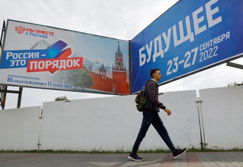 A young man walks past banners informing about a referendum on the joining of Russian-controlled regions of Ukraine to Russia, in the Russian-controlled city of Melitopol in the Zaporizhzhia region, Ukraine September 26, 2022. Banners read: "Russia is order" (L) and "Future. 23-27 September 2022". REUTERS/Alexander Ermochenko