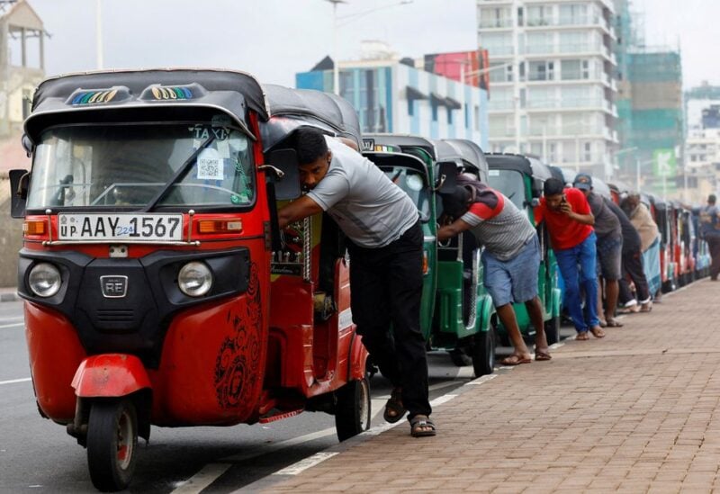 Drivers push auto rickshaws in a line to buy petrol from a fuel station, amid Sri Lanka's economic crisis, in Colombo, Sri Lanka, July 29, 2022. REUTERS/Kim Kyung-Hoon