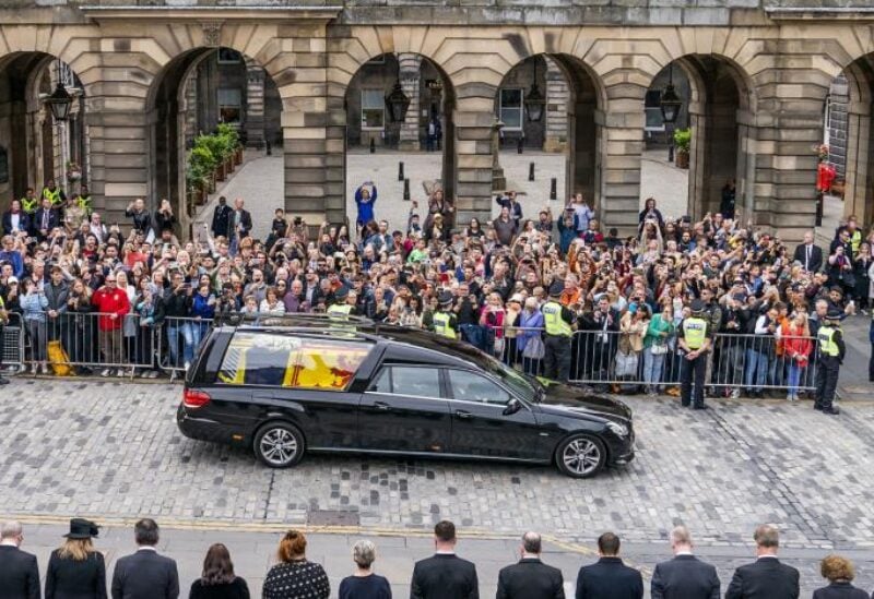 The hearse carrying the coffin of Queen Elizabeth II, draped with the Royal Standard of Scotland, passes the City Chambers on the Royal Mile, Edinburgh, on the journey from Balmoral to the Palace of Holyroodhouse in Edinburgh, September 11, 2022. (Jane Barlow/Pool Photo via AP)