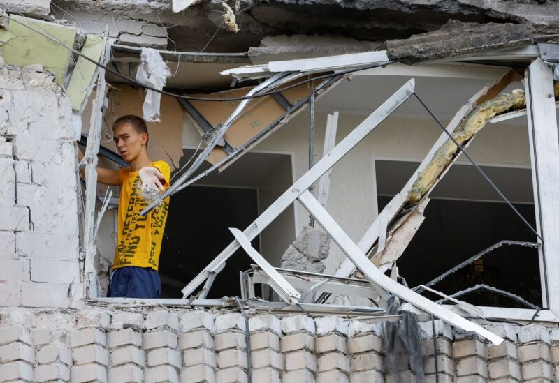 A local resident removes debris inside a multi-storey apartment block damaged by shelling in the course of Ukraine-Russia conflict in the Russian-controlled city of Enerhodar in the Zaporizhzhia region, Ukraine September 1, 2022. REUTERS/Alexander Ermochenko