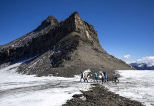 Hikers walk past the newly uncovered Zanfeluron path, as a split of the Sex-Rouge and the Zanfleuron Glacier revealed the path for the first time in 2000 years due to this summer heatwave, at Glacier 3000 in Les Diablerets, Switzerland, September 11, 2022. REUTERS/Denis Balibouse