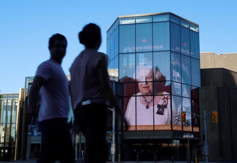 FILE PHOTO:People walk by as a tribute to Queen Elizabeth appears on the National Arts Centre, after Queen Elizabeth's passing, in Ottawa, Ontario, Canada, September 8, 2022. REUTERS/Patrick Doyle/File Photo