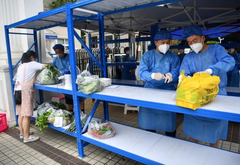 Workers in protective suits prepare to deliver food supplies placed on a rack outside a residential compound to its residents, amid a lockdown to curb the coronavirus disease (COVID-19) outbreak in Chengdu, Sichuan province, China September 2, 2022. cnsphoto via REUTERS