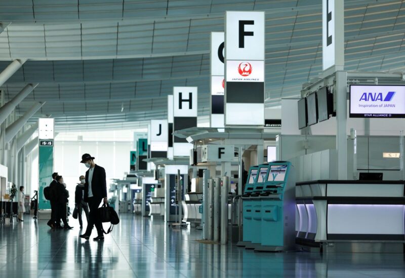 Passengers wearing protective face masks, amid the coronavirus disease (COVID-19) pandemic, walk at the Haneda airport, in Tokyo, Japan June 13, 2021. REUTERS/Androniki Christodoulou