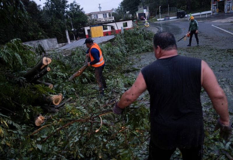 People clear a road from a fallen tree after Hurricane Fiona affected the area in Yauco, Puerto Rico September 18, 2022. REUTERS