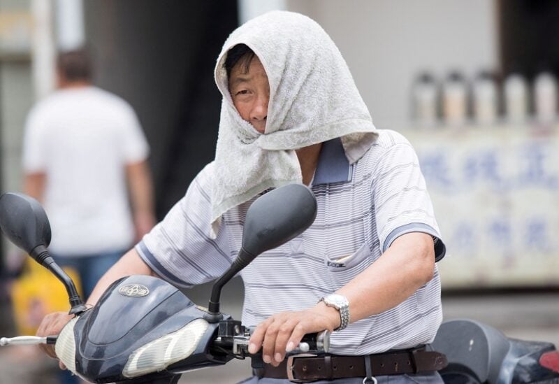 FILE PHOTO: A man is seen with a towel tied around his head to escape hot weather as a heat wave hits Hangzhou, Zhejiang province, China, July 10, 2017. Picture taken July 10, 2017. REUTERS/Stringer ATTENTION EDITORS - THIS IMAGE WAS PROVIDED BY A THIRD PARTY. CHINA OUT. NO COMMERCIAL OR EDITORIAL SALES IN CHINA./File Photo