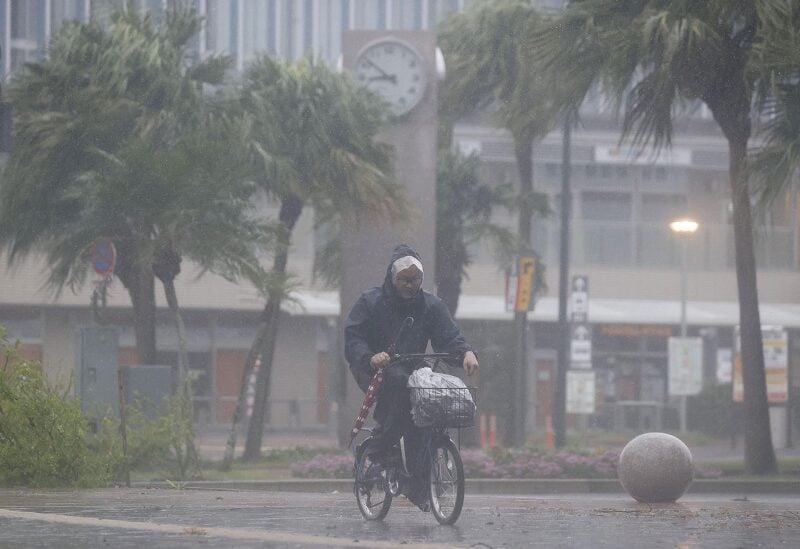 A man on a bicycle rides past in the heavy rain and wind caused by Typhoon Nanmadol in Miyazaki on Japan's southernmost main island of Kyushu September 18, 2022, in this photo taken by Kyodo. Mandatory credit Kyodo via REUTERS ATTENTION EDITORS - THIS IMAGE WAS PROVIDED BY A THIRD PARTY. MANDATORY CREDIT. JAPAN OUT. NO COMMERCIAL OR EDITORIAL SALES IN JAPAN