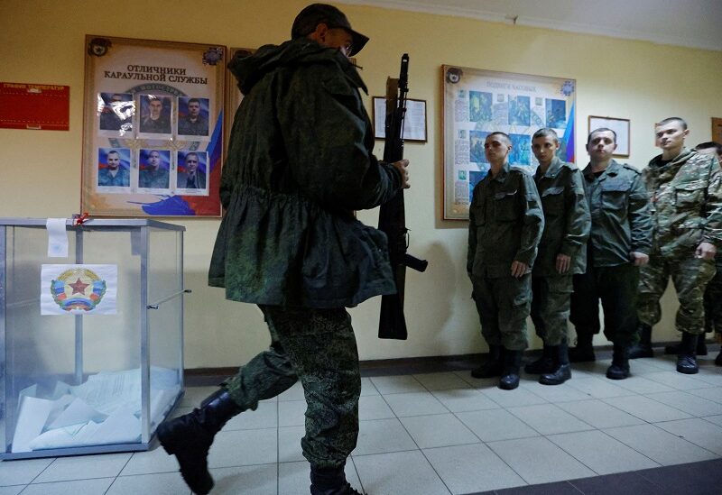 A service member of the self-proclaimed Luhansk People's Republic (LPR) walks with his rifle after voting during a referendum on joining LPR to Russia, at a military facility in Luhansk, Ukraine September 23, 2022. REUTERS/Alexander Ermochenko