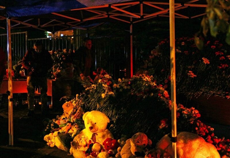 People bring flowers and toys to a makeshift memorial for the victims of a school shooting in Izhevsk, Russia September 26, 2022. REUTERS/Stringer