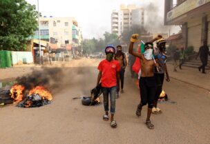 Protesters march past burning tires during a rally against the military rule following the last coup, in Khartoum, Sudan September 13, 2022. REUTERS/Mohamed Nureldin Abdallah