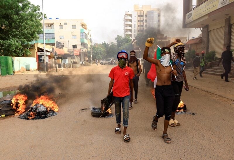 Protesters march past burning tires during a rally against the military rule following the last coup, in Khartoum, Sudan September 13, 2022. REUTERS/Mohamed Nureldin Abdallah