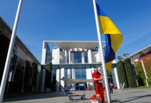 An employee puts a Ukrainian flag on a mast outside of a building of the German Chancellery ahead of visit of Ukrainian Prime Minister Denys Shmyhal, in Berlin, Germany September 4, 2022. REUTERS/Michele Tantussi