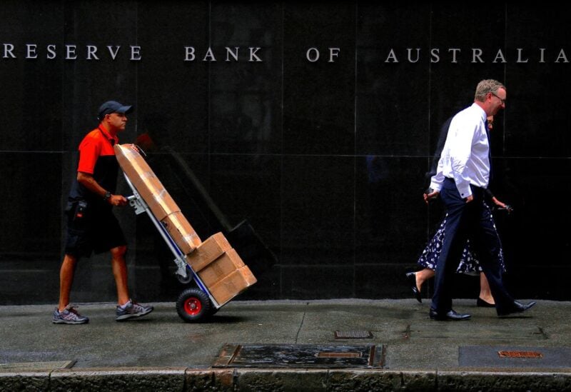 A worker pushing a trolley walks with pedestrians past the Reserve Bank of Australia (RBA) head office in central Sydney, Australia, March 7, 2017. REUTERS/David Gray