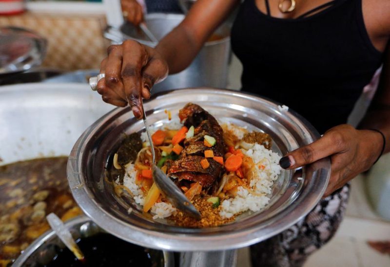 Restaurant assistant prepares a bowl of yassa for her customer in a restaurant at the Colobane market, in Dakar, Senegal, October 6, 2022 REUTERS/Ngouda Dione
