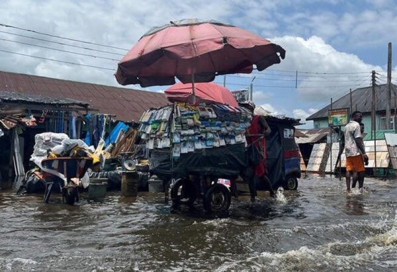 A man pushes a cart through flood water in Yenagoa Nigeria, October 18, 2022. REUTERS/Tife Owolabi