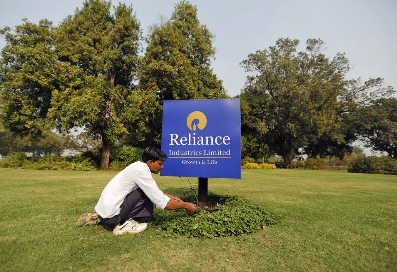 A gardener works next to a board of Reliance Industries Ltd at Gandhinagar in Gujarat, India, January 19, 2016. India's oil-to-telecoms conglomerate Reliance Industries Ltd posted a 39 percent rise in third-quarter net profit, beating analysts' estimates, bolstered by the highest refining margin in seven years. REUTERS/Amit Dave