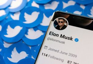 Elon Musk's Twitter profile is seen on a smartphone placed on printed Twitter logos in this picture illustration taken April 28, 2022. REUTERS/Dado Ruvic/Illustration/File Photo