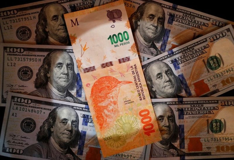 A one thousand Argentine peso bill sits on top of several one hundred U.S. dollar bills in this illustration picture taken October 17, 2022. REUTERS