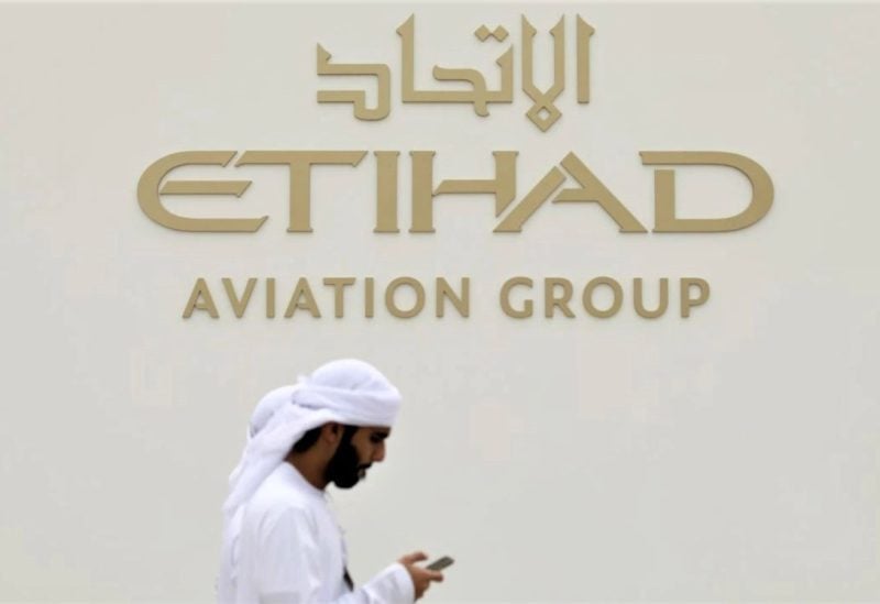 A visitor walks past the Etihad Aviation Group logo on display during the fifth day of Dubai Air Show in Dubai, United Arab Emirates November 21, 2019. REUTERS/Christopher Pike