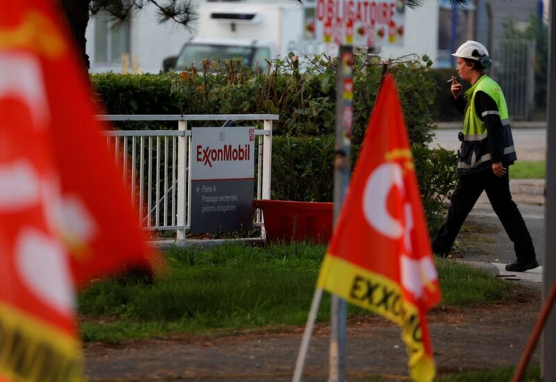A worker walks past CGT trade union flags in front of the ExxonMobil oil refinery in Port-Jerome-sur-Seine, France, October 12, 2022. REUTERS/Pascal Rossignol