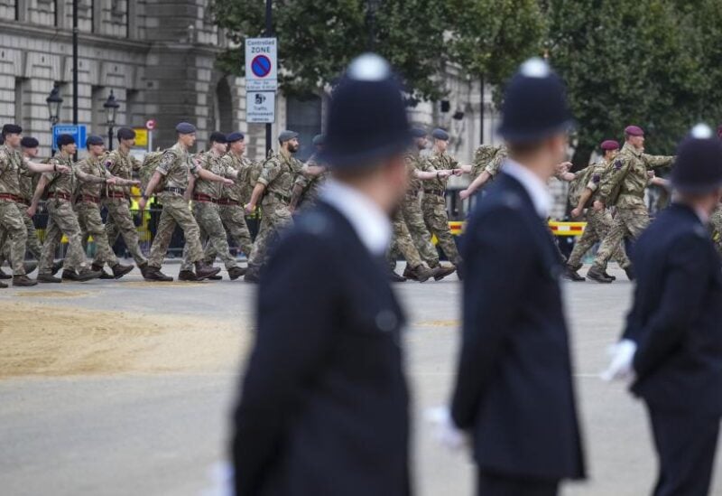 Police watch as armed forces personnel march into position in London ahead of the Queen’s funeral (Emilio Morenatti/PA) (PA Wire)