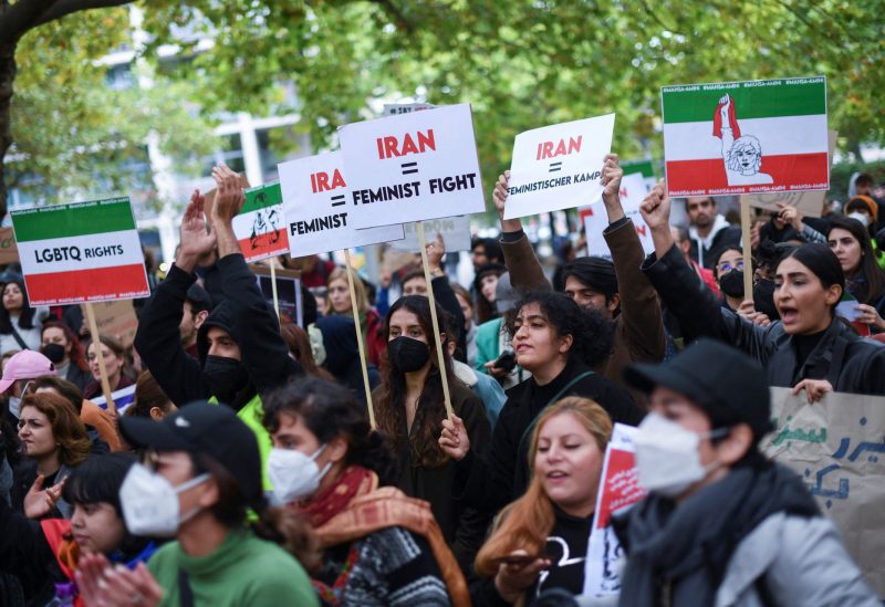 Protesters hold signs at a demonstration, following the death of Mahsa Amini, a woman who died last week in Tehran after being arrested by Iranian morality police, in Berlin, Germany September 24, 2022. REUTERS/Annegret Hilse